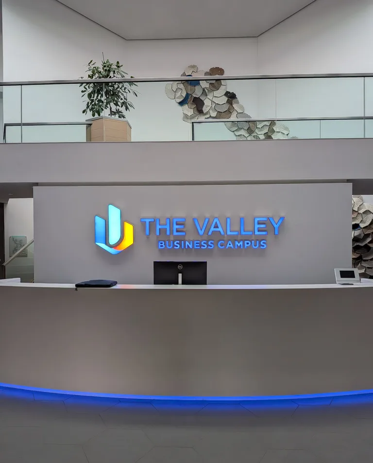 Realisiertes Kundenprojekt: Beleuchtete Leuchtbuchstaben und Firmenlogo von The Valley Business Campus im Empfangsbereich