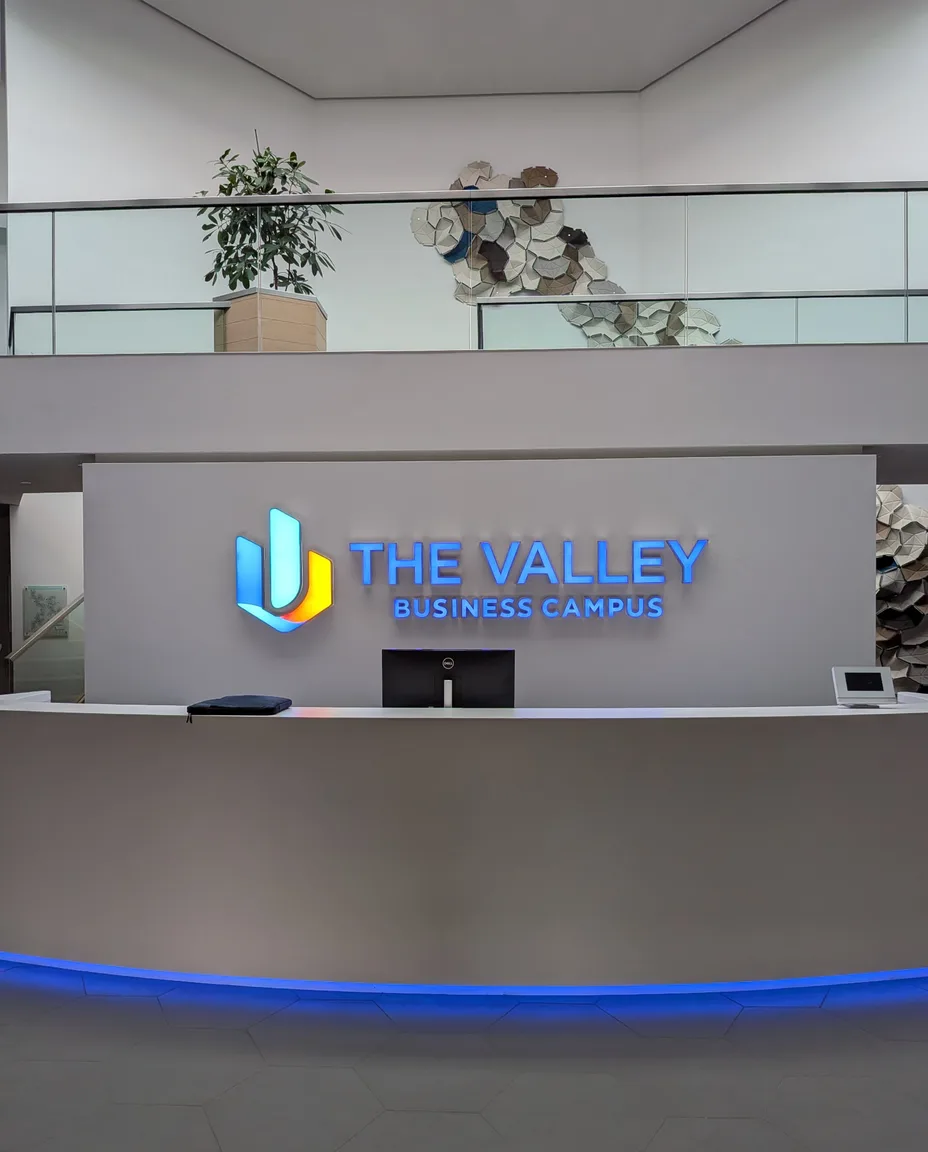 Realisiertes Kundenprojekt: beleuchtete Leuchtbuchstaben und Firmenlogo von The Valley Business Campus im Empfangsbereich