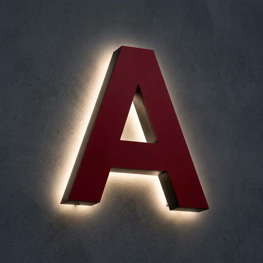 Roter 3D Buchstabe mit Backlit-Hintergrundbeleuchtung an einer Wand.